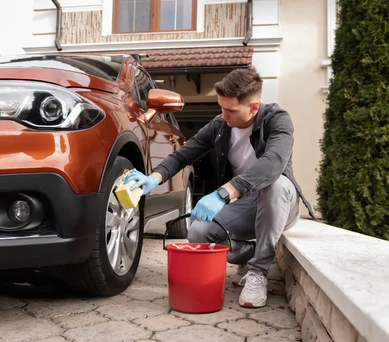 Lavage auto à domicile Nesles-la-Vallée : professionnel intervenant sur un véhicule